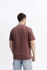 Remera de manga corta color gris oscuro con cuello redondo y un estampado rectangular frontal que simula una obra de arte paisajística en blanco y negro.