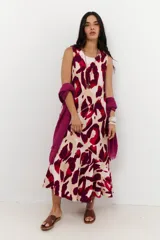 Vestido midi sin mangas, con escote redondo, de corte recto y ligero vuelo en el ruedo. Presenta un estampado animal print abstracto en tonos rojo, bordó y beige.