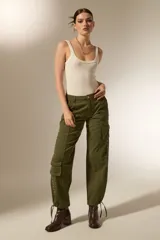 Pantalon cargo de algodon color verde militar, de tiro alto, con bolsillos laterales tipo cargo, detalle de ojales metálicos en los laterales y cordones ajustables en los tobillos.