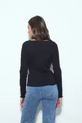 Remera de manga larga con ajuste al cuerpo, confeccionada en tejido acanalado de color marrón. Presenta cuello redondo y terminaciones con borde ondulado en puños y ruedo.