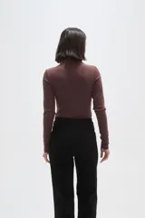 Body de manga larga con cuello alto, confeccionado en tejido al cuerpo.