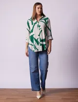 Camisa de manga larga con estampado abstracto en tonos verde y blanco. Cuello con solapa y abertura central con botones. Largo de manga regulable con presilla y botón. Terminación de ruedo anudada opcional.