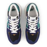 Championes urbanos New Balance con diseño multicolor en tonos azul marino, verde, negro y crema. Presentan una silueta moderna con paneles de gamuza y malla, el logo N característico en los laterales y una suela de plataforma en color blanco con base de goma.