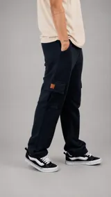 Pantalón tipo jogger cargo de color azul marino, con bolsillos laterales amplios y parche decorativo en cuero sintético. Presenta un corte holgado y cómodo.