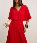 Vestido evasê midi color rojo, confeccionado en tejido airflow con escote en V, mangas cortas amplias y cintura elastizada. Material más sostenible: poliéster certificado GRS.