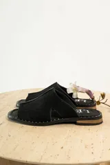 Sandalias negras de gamuza con puntera descubierta y detalle de tachas plateadas en la suela.