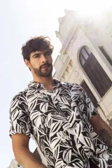 Camisa de manga corta con estampado de hojas en blanco y negro, confeccionada en rayón.