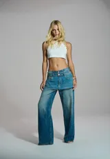 Pantalón wide leg de mezclilla azul con sobrefalda incorporada y diseño de tiro bajo.