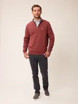 Sweater de punto color gris, con cuello alto y cierre frontal parcial con detalle de tela a cuadros en el interior. Presenta puños y ruedo acanalados y logo bordado en el pecho.