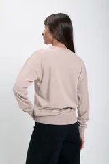 Buzo tejido de punto con cuello redondo a la base, de calce holgado y mangas largas con puños acanalados.
