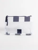 Bolso tipo tote grande, resistente al agua, con diseño de rayas verticales rojas y blancas. Cuenta con asas largas de hombro, cierre superior y parche de cuero con logo grabado. Incluye neceser transparente a juego con base y detalles a rayas.