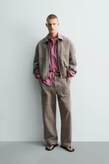 Cazadora de algodón de corte relajado, color marrón grisáceo con efecto lavado. Presenta cuello solapa con tachas metálicas, cierre frontal de cremallera, bolsillos de plastrón en la cadera y puños y bajo elásticos.