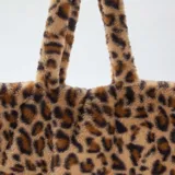 Bolso tipo shopper confeccionado en piel sintética con estampado de leopardo. Cuenta con dos asas superiores fijas y un diseño amplio y estructurado.