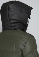 Campera puffer verde militar con capucha negra de cuero sintético, cierre frontal con cremallera y bolsillos laterales con cierre.