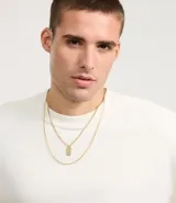 Collar doble dorado con cadena fina y dije rectangular.