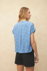 Blusa verde con estampado de hojas color salmón, cuello mao y mangas cortas.