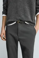 Pantalón de corte slim fit confeccionado en tejido elástico, con cintura elástica, cierre frontal con cremallera y botón, bolsillos laterales y bolsillos traseros de vivo.