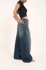 Pantalón de jean con corte baggy de tiro medio, diseño de cinco bolsillos y acabado desgastado en tono gris oscuro.
