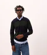 Suéter de punto con diseño de rayas horizontales anchas en bloques de color azul marino y verde oscuro. Presenta cuello tipo polo, mangas largas con puños acanalados y corte regular.