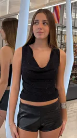 Top negro con acabado brillante y lúrex, sin mangas y con escote drapeado.