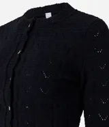 Saco de punto abierto color negro, con cuello redondo, manga larga y cierre frontal con botones. Presenta un diseño de textura tejida y detalle de encaje en el ruedo.