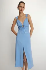 Vestido midi de corte recto con estampado de rayas verticales en tonos azul y blanco. Presenta escote en pico con detalle de abertura ajustable mediante lazada frontal, tirantes anchos con acabado fruncido y cierre lateral con cremallera oculta.
