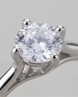 Anillo de plata 925 con piedra circonia central de corte redondo con engarce de cuatro puntas y diseño de banda clásica.