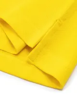 Chomba amarilla de corte slim, con cuello clásico, cartera de dos botones y logo de Tommy Hilfiger bordado en el pecho.