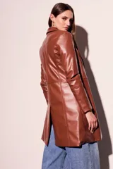 Trench marrón de cuero vegano, corte al cuerpo y largo hasta la rodilla.