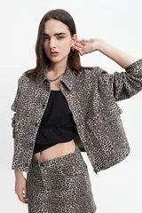 Campera de jean de mezclilla oscura, corte relajado, con cuello y bolsillos de parche con tapa y botón en el pecho. Presenta costuras en tono naranja/marrón claro.