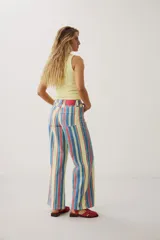 Pantalón wide leg de denim con diseño de rayas verticales multicolor en tonos amarillo, rojo y azul.