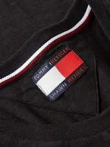Remera negra de corte slim, cuello redondo y manga corta con dobladillo. Logo de Tommy Hilfiger bordado en el pecho.