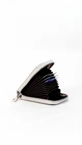 Tarjetero de diseño compacto en color tostado, con cierre perimetral metálico y visor frontal transparente para identificación o tarjetas.