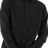 Camisa de manga larga Rip Curl modelo Classic Surf Washed, color negro con efecto lavado. Presenta cuello clásico, cierre frontal con botones y un bolsillo en el pecho con etiqueta de la marca.