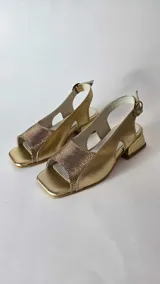 Sandalias de cuero combinadas en negro y beige, con puntera cuadrada, taco bajo y tira ajustable en el talón.
