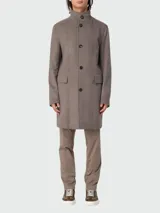 Abrigo largo color marrón claro, de corte recto, con cuello mao y cierre frontal con botones. Tiene bolsillos laterales con solapa y está confeccionado en lana y cachemira.