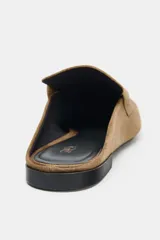 Mocasín destalonado de serraje color marrón, con copete subido, antifaz delantero con detalle metálico y punta cuadrada.