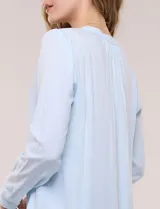 Blusa celeste fluida de viscosa, con escote en V y cuello mao, mangas largas y pliegue central en el delantero.