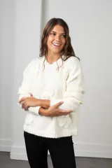 Buzo de punto color blanco, de corte holgado y cuello redondo, con diseño de flores aplicadas con detalles de mostacillas bordadas.