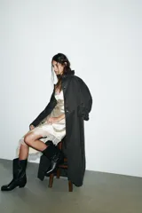 Gabardina larga color gris oscuro con efecto encerado, cuello solapa de pana, manga larga, bolsillos laterales con solapa y cierre frontal con botones ocultos.