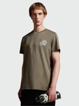 Remera de algodón color verde oliva, con cuello redondo y parche con logo de la marca en el pecho.