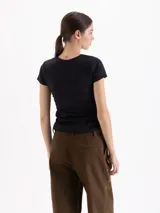 Top de algodón color negro, con cuello redondo, mangas cortas y diseño con frunces laterales que generan un efecto drapeado.