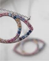 Collar de acero con baño de oro y dije en forma de ojo decorado con circonias multicolor.