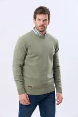 Buzo tejido de lana con escote redondo a la base y mangas largas. Presenta puños y ruedo acanalados, con un pequeño logo bordado en el pecho.