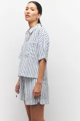 Short pijama a rayas verticales blancas y azules, con elástico en la cintura y cordones ajustables.