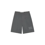 Bermudas formales Eme Studios modelo Golin Stormmist, de color gris oscuro, con bolsillos delanteros con solapa y botones, costuras frontales marcadas y estampa tipográfica en la pierna izquierda.