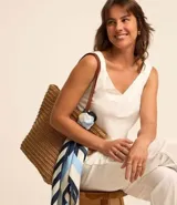 Pantalón celeste de corte recto, confeccionado en tejido de lino y viscosa. Presenta cintura elástica con lazo ajustable, bolsillos laterales y pliegues frontales.