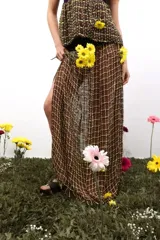 Falda larga de corte recto con caída fluida, confeccionada con una pretina tejida en punto elástico y cuerpo inferior tejido en telar con diseño de cuadrícula. Presenta un tajo lateral que aporta movimiento a la prenda.