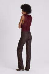 Pantalón de vestir marrón con textura, tiro bajo, bolsillos delanteros con labio y cierre metálico oculto, bolsillo sastrero en espalda, pierna con recortes en delantero y pinza en espalda.