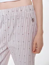 Pantalón de dormir de corte recto y calce relajado, confeccionado en popelina de algodón con estampado de rayas verticales y pequeños puntos bordados. Presenta cintura elastizada para mayor comodidad.